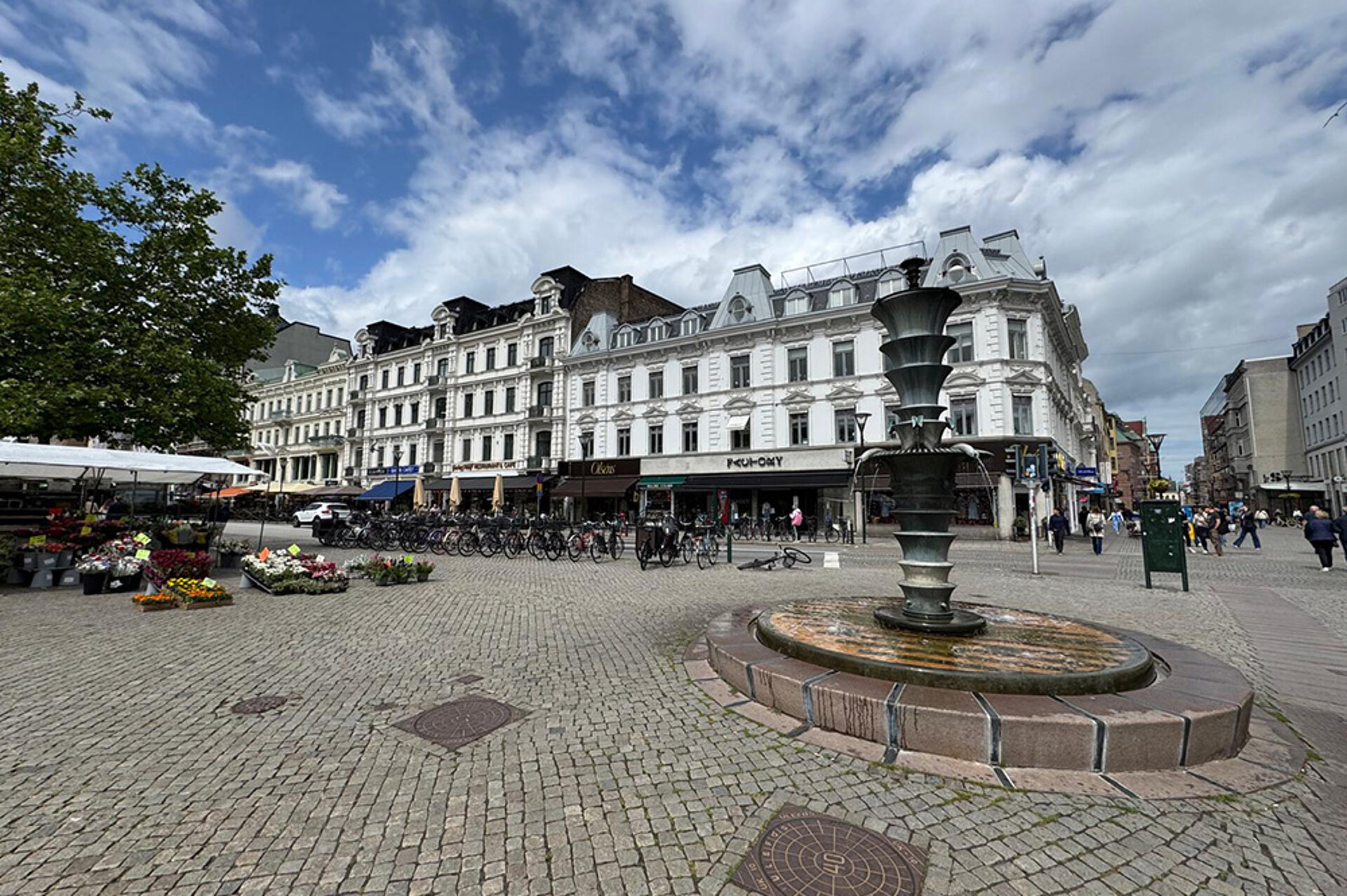 Malmö je ideální pro nakupování a výborné jídlo. Pohled na centrum Malmö s fontánou a vysokými budovami.